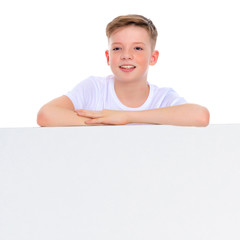 A boy of school age near a white advertising banner.