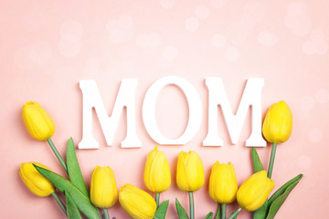Mothers day message with yellow tulips on pink background.