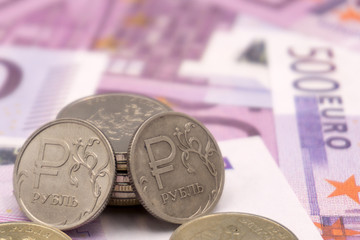 ruble coin on the background of Euro banknotes .