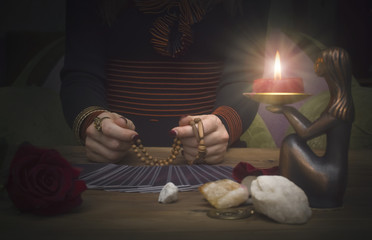 Tarot cards on the table. Fortune teller reading the future and holds in hands a rosary beads. Future reading concept.