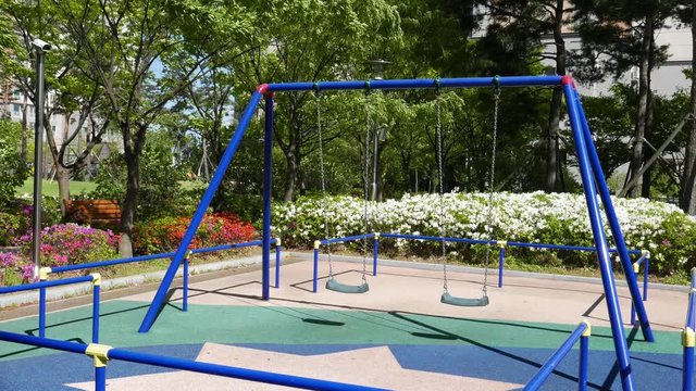 new swings in a mordern playground with fowers in Korea