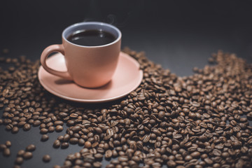 Cup of black coffee and roasted coffee beans.