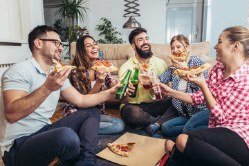 Group of young friends eating pizza.Home party.Fast food concept.