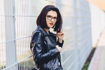 Woman in glasses in leather jacket on street