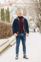 Guy in jacket stands in middle of alley