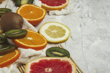Fresh Tropical Fruits, Grapefruit, Lemon, Orange, Kiwi on a Light Stone Background. Flat lay, top view