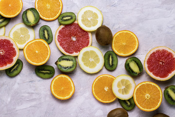Fresh Fruits, Grapefruit, Lemon, Orange, Kiwi on a Light Stone background. Copy space and a top view