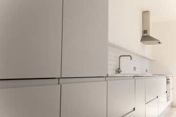 Modern kitchen interior with light grey cupboards