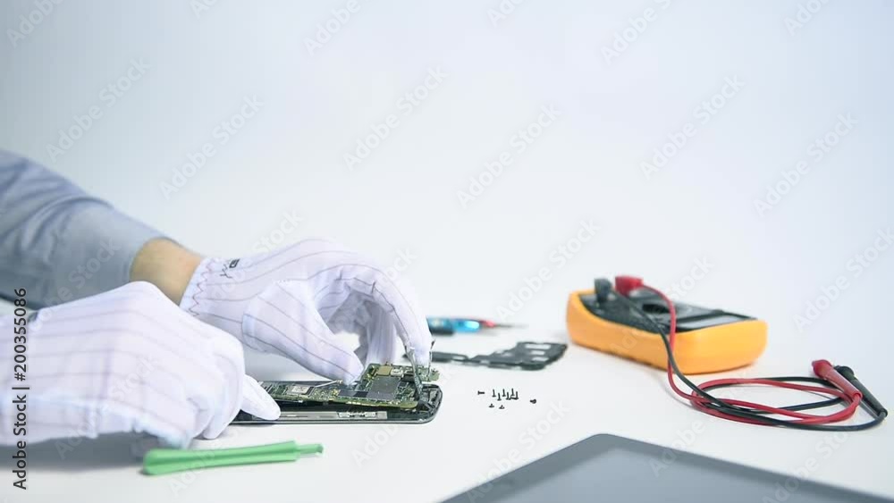 Poster professional it engineer replacing a motherboard of broken smartphone with care in a high-tech works