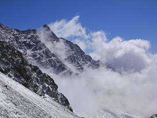 Fototapeta na wymiar View from the Laurebina La mountain pass, Nepal. Clouds creeping over a mountain peak.