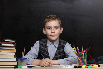 Pupil of junior school writes homework in his notebook