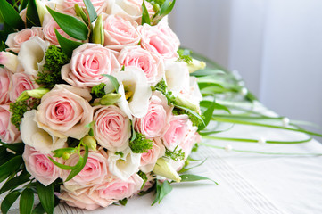 A bouquet of the bride with pink roses on the table.