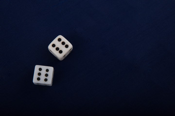 Two white dice cubes on blue background.