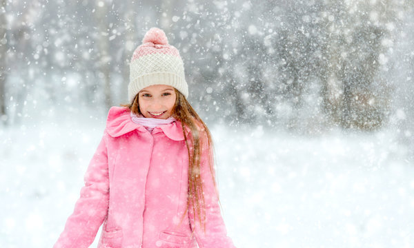 Smiling girl in whirl of snowflakes