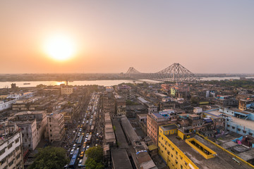 Aerial view of Kolkata city, India. Beautiful sunset over the famous Howrah bridge - The historic cantilever bridge on the river Hooghly, Calcutta, India.