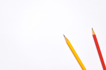Bright colorful pencils next to a blank sheet of paper. School supplies stationery on a wooden texture table. Trendy minimalism. Concept back to school. Top view