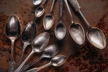 Old metal spoons on rusted background