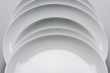 white plates in a row on white table