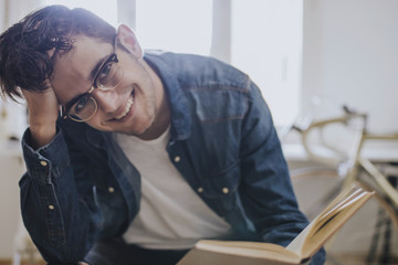 young at home reading a textbook or studying