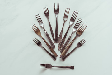 Composition of old metal forks on white background