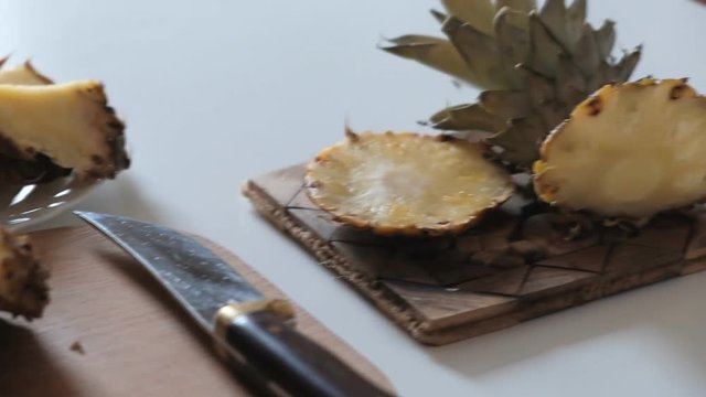 sliced pineapple on a white table and a wooden board