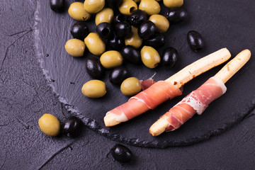 Traditional italian bread sticks grissini with prosciutto ham