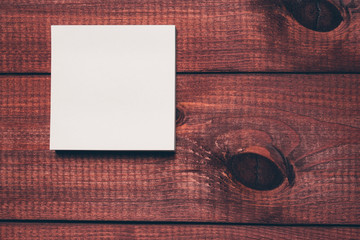 Sticky notes next to a blank sheet of paper. Work supplies stationery on a wooden texture table. Trendy minimalism. Concept of a modern freelancer workplace. Rustic cozy atmosphere