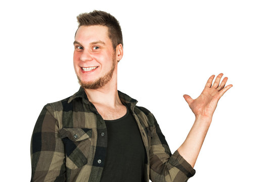 Young guy with beard and modern hairstyle mohawk, smiles and keeps his hand raised isolated on white background.