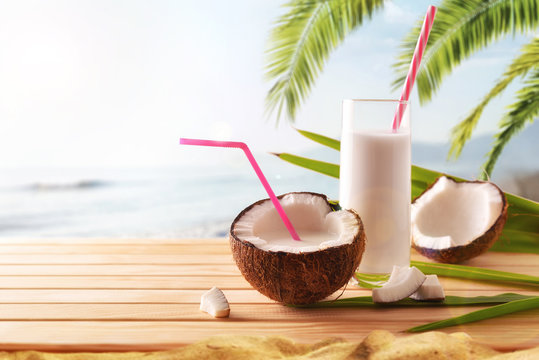 Coconut milk in fruit and glass on the beach