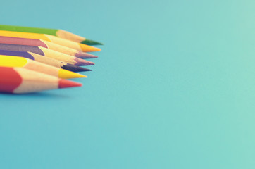 Colorful ground pencils group on a blue background.