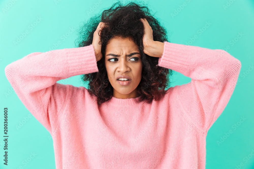 Wall mural Image closeup of distressed woman with headache grabbing head and expressing pain, isolated over blue background