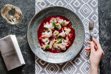 cropped shot of person holding fork and eating gourmet ceviche with dorado