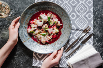 cropped shot of person holding plate with delicious meal with dorado