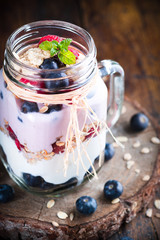 Combined fruit and yogurt in glass with rustic background.