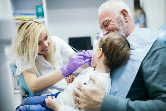 Two years old boy with his grandfather first time on dental chair