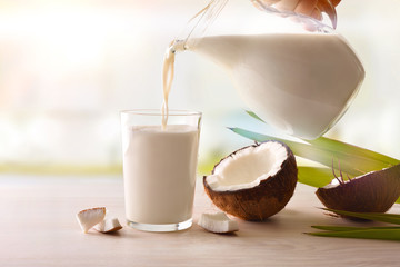 Filling a glass from a jug with coconut milk