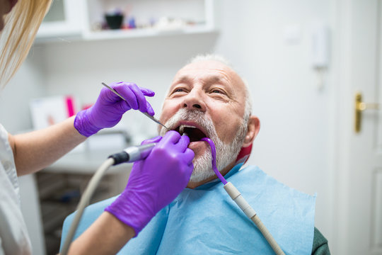 Senior man having dental treatment at dentist's office. 