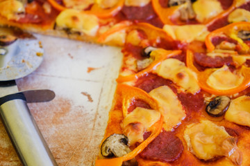 Cutting pepperoni pizza on slices with knife.