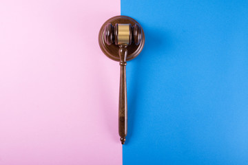 Judge gavel or auction on pink and blue background. Justice and auction.