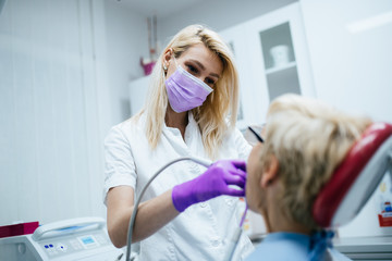 Senior woman having dental treatment at dentist's office. 
