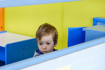 Cheerful little boy sitting and playing at playground