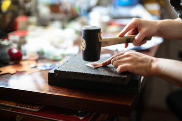 Fototapeta na wymiar Home workshop girl master rubber hammer knocks
