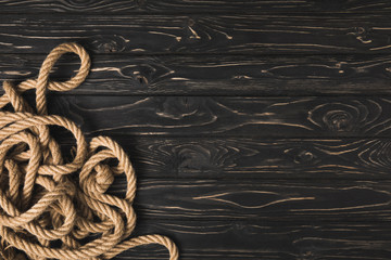 top view of brown nautical rope on dark wooden planks