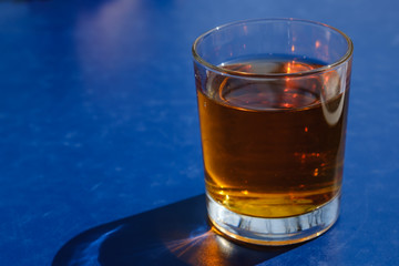 apple or grape clarified juice in glass on blue