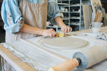 Hands make clay from various items for home and sale in the store and at the exhibition, ceramic items are made in hand, the clay billet becomes a ceramic dish, the ceramic master sculpts a beautiful 
