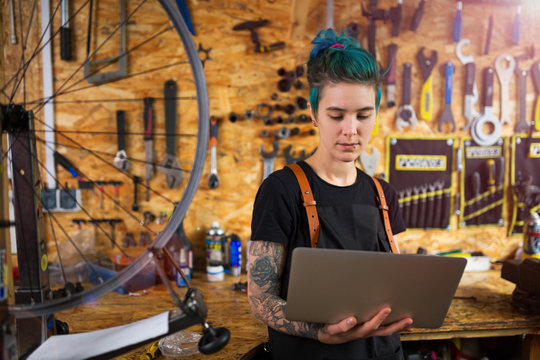Woman using a laptop in a bicycle repair shop
