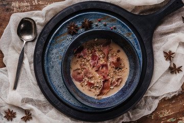 top view of delicious cream soup with fried potatoes and jamon