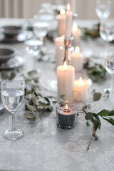 Wedding or festive table setting. Plates, wine glasses, candles and cutlery