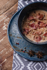 close-up view of fresh delicious cream soup with fried potatoes and jamon