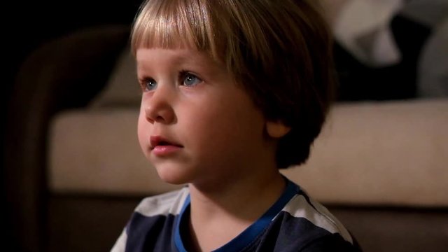 Boy watching television in dark living room